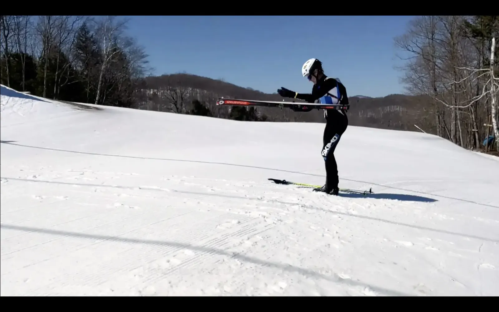 An image of a skimo racer unholstering his skis during a boot-to-skin transition