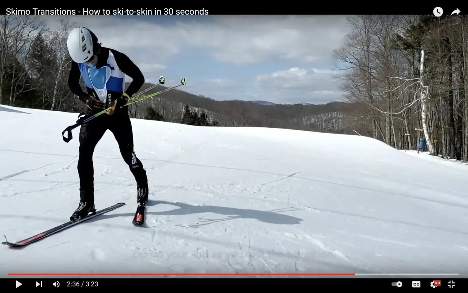 An image of a skimo racer finishing the ski-to-skin transition